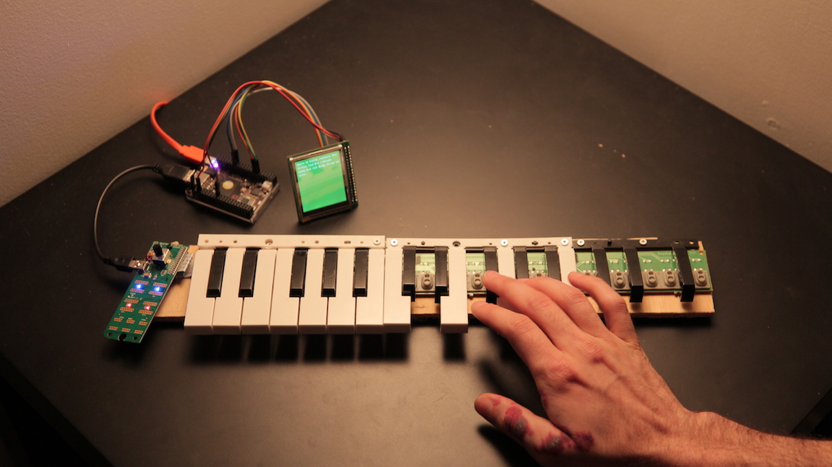 circuit boards connected to a screen with jumper wires and a deconstructed midi keyboard